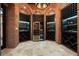 Wine cellar features a brick wall, a cooler, custom shelves, and black shelving at 8336 Boyla Ct, Windermere, FL 34786