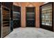 Wine cellar features brick walls, custom shelves, black shelving, and travertine flooring at 8336 Boyla Ct, Windermere, FL 34786