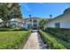 Charming white home with manicured hedges, inviting entrance, and walkway leading to the front door at 8606 Summerville Pl, Orlando, FL 32819