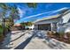 Three-car garage featuring brown doors and brick paver driveway under a clear blue sky at 8606 Summerville Pl, Orlando, FL 32819