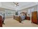 Spacious main bedroom is naturally lit with a bay window, a ceiling fan, and plush neutral carpeting at 9318 Lake Hickory Nut Dr, Winter Garden, FL 34787