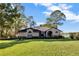 Charming single-story brick home with lush lawn, mature trees, and serene lake views at 9318 Lake Hickory Nut Dr, Winter Garden, FL 34787