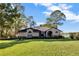 Sprawling home exterior features manicured landscaping, brick facade, and lake view at 9318 Lake Hickory Nut Dr, Winter Garden, FL 34787