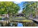 A single-story home with large windows and mature trees, situated on a lake at 9318 Lake Hickory Nut Dr, Winter Garden, FL 34787