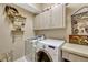 Functional laundry room with white cabinets, modern appliances, and charming decor, adding convenience to daily chores at 9318 Lake Hickory Nut Dr, Winter Garden, FL 34787