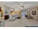 Bright living room boasts neutral tones, recessed lighting, a ceiling fan, and sliding glass doors to the outdoors at 9318 Lake Hickory Nut Dr, Winter Garden, FL 34787