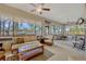 Bright sunroom with ample natural light, plush seating, and tranquil water views at 9318 Lake Hickory Nut Dr, Winter Garden, FL 34787