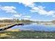 Waterfront view of the lake with a dock and a boat, surrounded by greenery at 9318 Lake Hickory Nut Dr, Winter Garden, FL 34787
