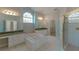 Luxurious bathroom with jacuzzi tub, shower, dual vanities and arched window at 9833 Camberley Cir, Orlando, FL 32836