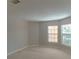 Empty bedroom showcasing two large windows, neutral walls and carpet at 9833 Camberley Cir, Orlando, FL 32836