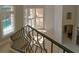 Upper foyer with wrought iron railing overlooking a grand foyer and a wall of bright windows at 9833 Camberley Cir, Orlando, FL 32836