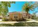 Charming angle of a Mediterranean-style home showcasing a tile roof, stucco facade, and lush landscaping under a sunny sky at 9833 Camberley Cir, Orlando, FL 32836