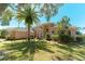 Inviting Mediterranean home with a tile roof, stucco facade, and mature landscaping including a beautiful palm tree at 9833 Camberley Cir, Orlando, FL 32836