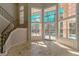 Bright living room with staircase, tile flooring, and tall windows overlooking backyard at 9833 Camberley Cir, Orlando, FL 32836