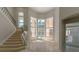 Bright living room with staircase, tile flooring, and tall windows overlooking the pool at 9833 Camberley Cir, Orlando, FL 32836