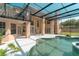Enclosed pool area featuring a custom pool design, pristine patio, and a view of the home's elegant rear facade at 9833 Camberley Cir, Orlando, FL 32836