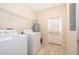 Functional laundry room with washer, dryer, storage shelves, and convenient access to the exterior and breaker box at 9951 Alliteration Aly, Winter Garden, FL 34787