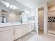 A spacious bathroom with double vanities, a shower with mosaic details, and modern fixtures at 1003 Jack Nicklaus Ct, Kissimmee, FL 34747