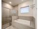Bathroom featuring a glass-enclosed shower, soaking tub, neutral tile and modern fixtures at 1003 Jack Nicklaus Ct, Kissimmee, FL 34747