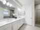 Bright bathroom featuring a double vanity with marble countertop, modern lighting, and a glass-enclosed shower at 1003 Jack Nicklaus Ct, Kissimmee, FL 34747