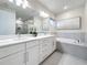 Bathroom with double vanity with white counters, soaking tub, and tiled shower at 1003 Jack Nicklaus Ct, Kissimmee, FL 34747