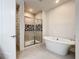 Modern bathroom featuring soaking tub, tiled shower with glass door and patterned backsplash at 1003 Jack Nicklaus Ct, Kissimmee, FL 34747