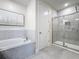 Bathroom featuring soaking tub, walk-in shower with glass door and neutral tile at 1003 Jack Nicklaus Ct, Kissimmee, FL 34747