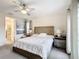Bedroom with ceiling fan, connected primary bath, and natural light from balcony door at 1003 Jack Nicklaus Ct, Kissimmee, FL 34747