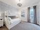 Cozy bedroom features a bunk bed, decorative wallpaper accent, and stylish chandelier lighting at 1003 Jack Nicklaus Ct, Kissimmee, FL 34747