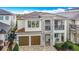 A stunning two-story home showcasing a stone facade, a two-car garage, and a private balcony at 1003 Jack Nicklaus Ct, Kissimmee, FL 34747