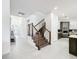 Bright foyer with tile flooring, modern staircase, and views into the kitchen and entry at 1003 Jack Nicklaus Ct, Kissimmee, FL 34747