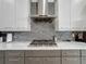Modern kitchen featuring a sleek stainless steel range hood and a stylish backsplash adding character to the space at 1003 Jack Nicklaus Ct, Kissimmee, FL 34747