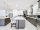 Bright kitchen features modern gray and white cabinets, stainless steel appliances, and a large island with bar seating at 1003 Jack Nicklaus Ct, Kissimmee, FL 34747