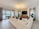 Large living room with a plush sofa and sliding glass doors leading to the pool area at 1003 Jack Nicklaus Ct, Kissimmee, FL 34747