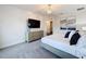 Spacious primary bedroom with stylish chandelier, decorative wall art, and view to connected primary bath at 1003 Jack Nicklaus Ct, Kissimmee, FL 34747