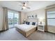 Bedroom with king bed, ceiling fan, and a sliding glass door opening onto a private balcony at 1003 Jack Nicklaus Ct, Kissimmee, FL 34747