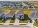 Aerial view of property with manicured lawns, landscaping, and surrounding neighborhood with houses with solar panels at 1209 Mattie Pointe Blvd, Auburndale, FL 33823