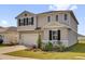 Charming two-story home with a well-manicured front lawn and an attached two-car garage, showcasing modern design at 1209 Mattie Pointe Blvd, Auburndale, FL 33823