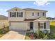 Charming two-story home with a two-car garage, well-maintained lawn, and complemented by colorful flowers at 1209 Mattie Pointe Blvd, Auburndale, FL 33823