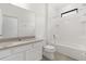 Bright bathroom with a granite countertop vanity, white cabinets, and tub with shower at 1242 Butterfly Orchid Rd, Davenport, FL 33837