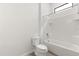 A clean bathroom featuring a toilet, a bathtub with shower, and a small window at 1242 Butterfly Orchid Rd, Davenport, FL 33837