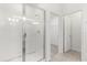 A bright bathroom showing an enclosed glass shower and a doorway to a walk-in closet at 1242 Butterfly Orchid Rd, Davenport, FL 33837