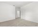 Bedroom with neutral carpet, white walls, and a doorway leading to another room at 1242 Butterfly Orchid Rd, Davenport, FL 33837