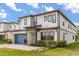 Charming two-story home with a blue garage door, modern windows and manicured landscaping at 1242 Butterfly Orchid Rd, Davenport, FL 33837