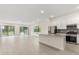 Open-concept living area features an island kitchen, stainless steel appliances, and sliding glass doors to the pool at 1242 Butterfly Orchid Rd, Davenport, FL 33837