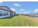 Expansive backyard with lush green grass, covered patio, and views of the lake is ideal for outdoor living at 16629 Broadwater Ave, Winter Garden, FL 34787