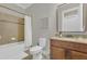 Bright bathroom featuring a bathtub with shower, and a vanity with granite countertop and dark wood cabinetry at 16629 Broadwater Ave, Winter Garden, FL 34787