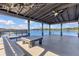 A covered dock boasts seating, table, ceiling fan, and waterfront access on a sunny day at 16629 Broadwater Ave, Winter Garden, FL 34787
