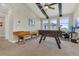 Spacious game room featuring a foosball table, shuffleboard, and comfortable workspace near bright windows at 16629 Broadwater Ave, Winter Garden, FL 34787