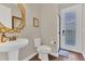 Stylish powder room with pedestal sink, round mirror, and outdoor access door provides convenience and functionality at 16629 Broadwater Ave, Winter Garden, FL 34787